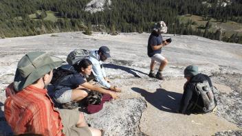 TA Ryan points out glacial polish on Lembert Dome to students Tyler, Regina, Carla, and Tommy