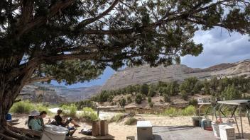 Trip members lounding under the camp_s central tree as a rainstorm approached (Photo_ Nick Santos)