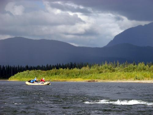 river with raft and mountains in the distance